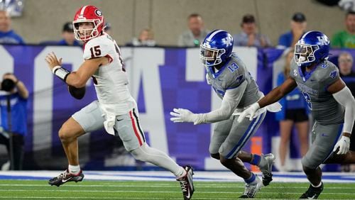 Georgia quarterback Carson Beck (15) is chased by Kentucky linebackers J.J. Weaver (13) and Jamon Dumas-Johnson (2) during the second half of an NCAA college football game, Saturday, Sept. 14, 2024, in Lexington, Ky. (AP Photo/Darron Cummings)