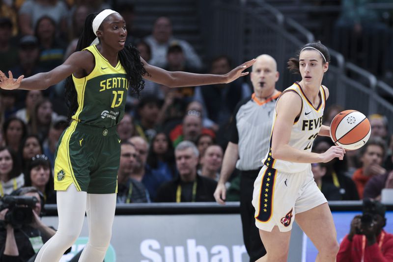 Indiana Fever guard Caitlin Clark is defended by Seattle Storm center Ezi Magbegor (13) during the first half of a WNBA basketball game Wednesday, May 22, 2024, in Seattle. (AP Photo/Jason Redmond)