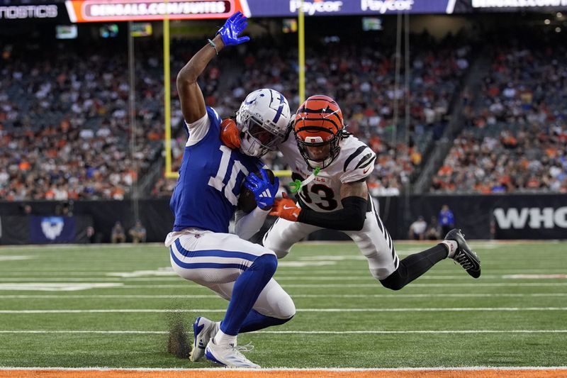 Indianapolis Colts wide receiver Adonai Mitchell (10) breaks a tackle by Cincinnati Bengals safety Daijahn Anthony (33) during a 9-yard touchdown reception in the first half of a preseason NFL football game, Thursday, Aug. 22, 2024, in Cincinnati. (AP Photo/Carolyn Kaster)