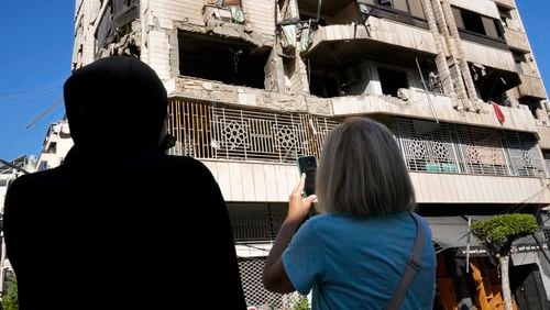 Lebanese women stand in front an apartment in a multistory building hit by Israeli airstrike, in central Beirut, Lebanon, Thursday, Oct. 3, 2024. (AP Photo/Hussein Malla)