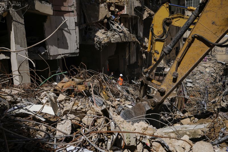 Rescuers sift through the rubble as they search for people still missing at the site of Friday's Israeli strike in Beirut's southern suburbs, Monday, Sept. 23, 2024. (AP Photo/Hassan Ammar)