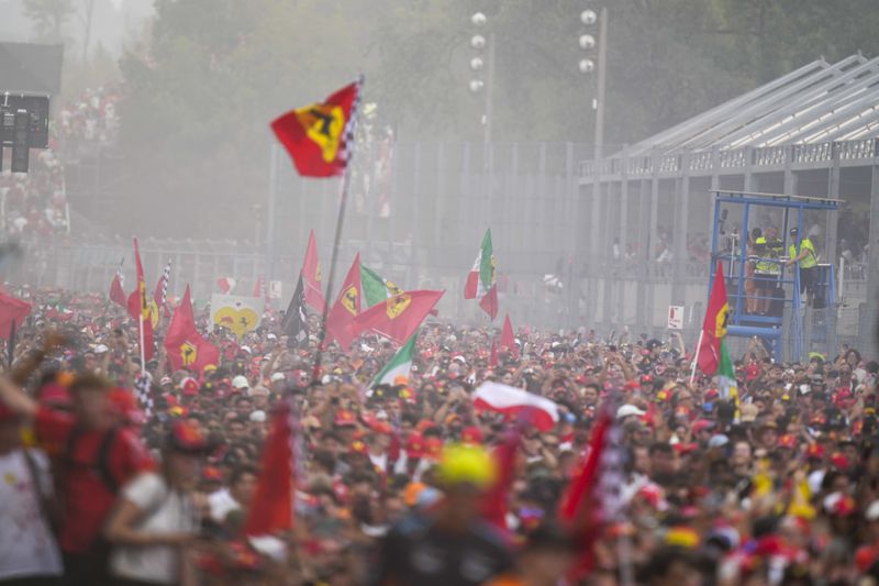 Supporters celebrate victory of Ferrari driver Charles Leclerc of Monaco after the Formula One Italian Grand Prix race at the Monza racetrack, in Monza, Italy, Sunday, Sept. 1, 2024. (AP Photo/Luca Bruno)