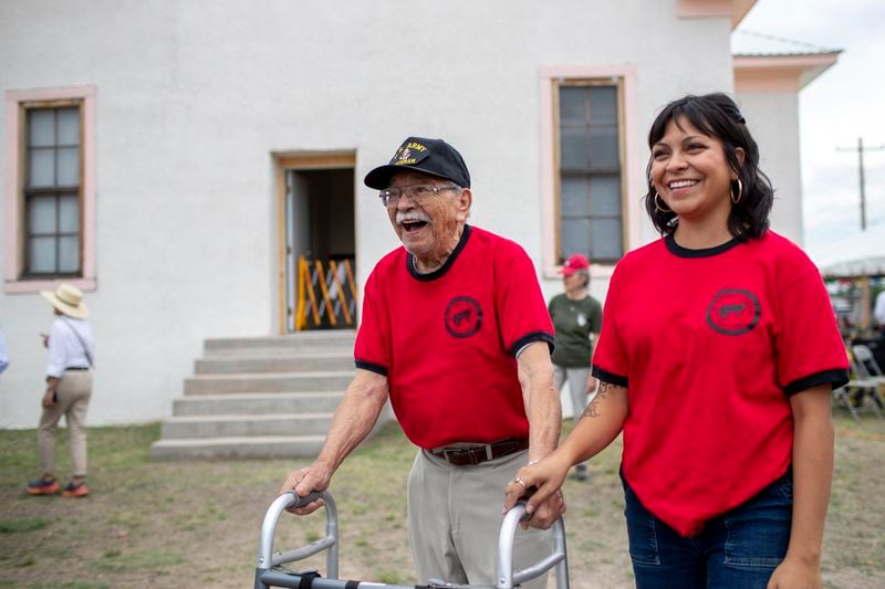 Alumni Lionel Salgado walks the Blackwell school grounds with help from his grand daughter Sarah Madero during its inauguration as the newest National Historic Site in Marfa, Texas, Saturday, Sept. 14, 2024. (AP Photo/Andres Leighton)