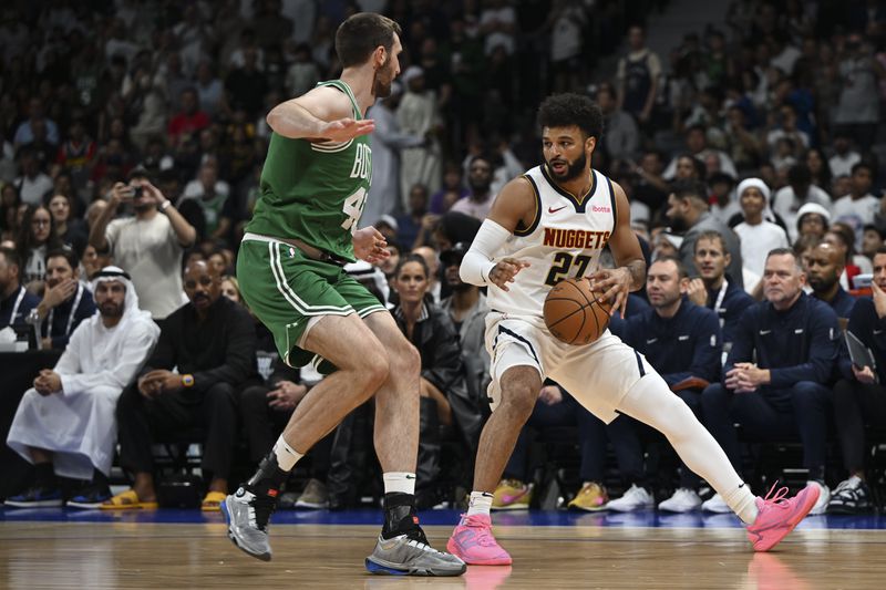 Boston Celtics Luke Kornet guards Denver Nuggets Jamal Murray during a preseason game between Boston Celtics and Denver Nuggets in Abu Dhabi, United Arab Emirates, Friday, Oct. 4, 2024. (AP Photo/Martin Dokoupil)