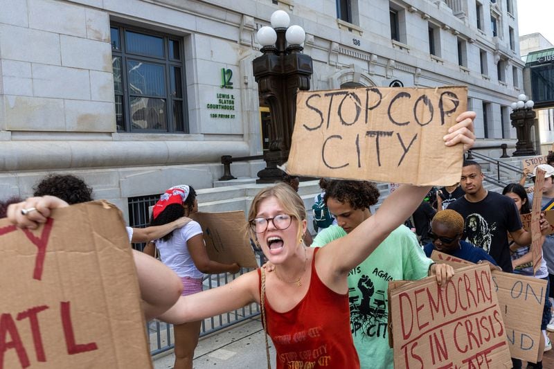 Protestors against Atlanta's planned public safety training center, known by some as "Cop City," gather at Fulton County Courthouse in Atlanta on Monday, Aug. 14, 2023, as Fulton prosecutors present a their election interference case against former President Donald Trump and others to a grand. (Arvin Temkar/The Atlanta Journal-Constitution/TNS)