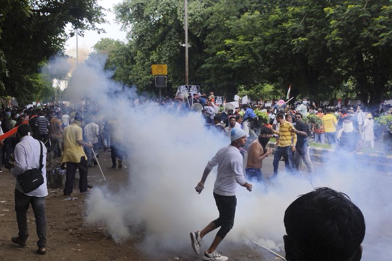 Police fire tear gas shells to disperse people protesting against the rape and murder of a resident doctor at a government hospital earlier this month, in Kolkata, India, Tuesday, Aug. 27, 2024. (AP Photo/Bikas Das)