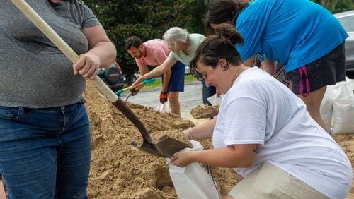 Renee Cowart helps Nikki Zuaro fill sand bags with sand at the Savannah Fire Station #7 on Sunday, August 4, 2024 in Savannah, GA. (AJC Photo/Katelyn Myrick)