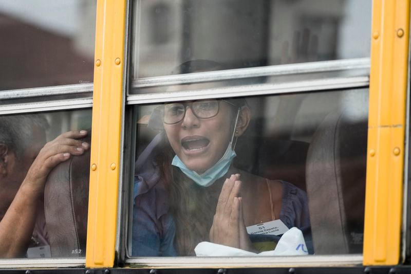 Lucia Garcia gestures from a bus after being released from a Nicaraguan jail and landing at the airport in Guatemala City, Thursday, Sept. 5, 2024. (AP Photo/Moises Castillo)