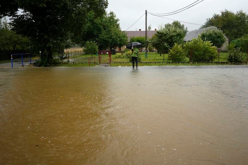 A resident takes a photo of a flooded street in Brantice, Czech Republic, Saturday, Sept. 14, 2024. (AP Photo/Petr David Josek)