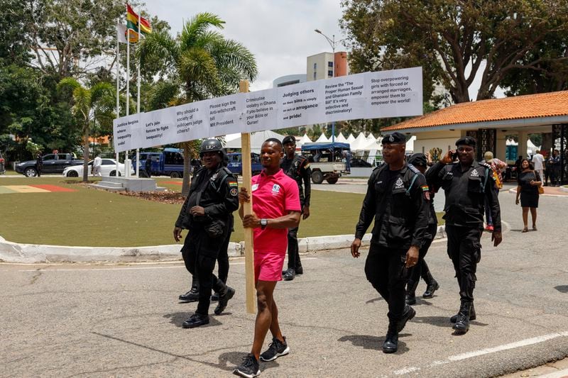 Texas Kadri Moro, the Executive Director of Arise for Justice International, protests with placards nailed on a cross on the street of Accra, Ghana, Thursday Sept 12, 2024. Texas Kadiri Moro is an unusual figure amid the LGBTQ+ rights activists in the coastal West African nation of Ghana. He is heterosexual, married to a woman and a father of six. He is a teacher. And he is a practising Muslim. (AP Photo/Misper Apawu)