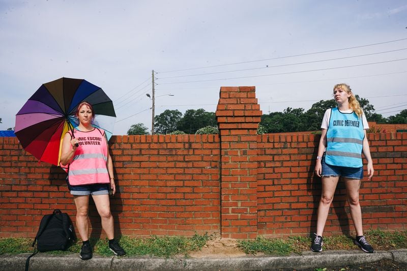 Marcee Lichtenwald, left, and Max Carwile volunteer together to "protect the privacy and dignity of women's health care" by escorting women into abortion clinics while activists are protesting outside a facility in Forest Park. (Olivia Bowdoin for The Atlanta Journal-Constitution)