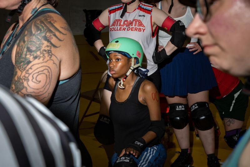 Olivia Agoruah (center), aka AA Dolly, listens during a meeting at the Atlanta Roller Derby practice facility in Mableton on Wednesday, May 22, 2024. (Arvin Temkar / AJC)