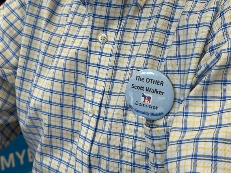 Scott Abbot Walker, a Democratic candidate for the Wisconsin state Legislature, wears a pin to differentiate himself from Wisconsin's former governor, Republican Scott Walker, during a visit to the Grant County Democratic Party headquarters in Platteville, Wis. on Friday, Sept. 6, 2024. (AP Photo/Todd Richmond)