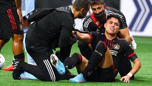 Atlanta United's Luiz Araujo goes down on the pitch shortly after scoring a goal against Sporting KC for a 1-0 lead in an MLS soccer match and has to leave the game Sunday in Atlanta. (Curtis Compton / Curtis.Compton@ajc.com}`