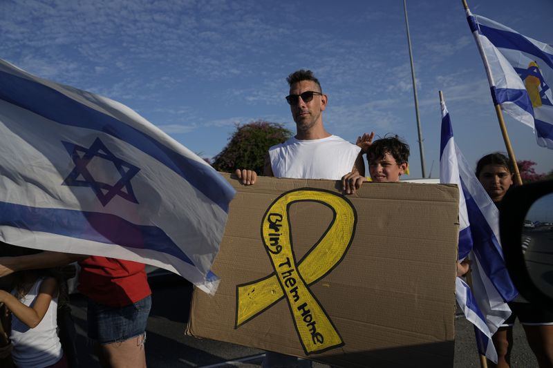 Relatives and friends of hostages held in the Gaza Strip by the Hamas militant group gather during a protest calling for their release as they take part in a convoy of vehicles to the Gaza border, near Ashkelon, southern Israel, Wednesday, Aug. 28, 2024. (AP Photo/Tsafrir Abayov)