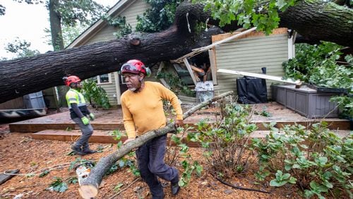 Dad’s Tree Service’s Gary Cooper, front, and Mike Crear, work to remove an oak tree from a Kirkwood home on Friday, Sept 27, 2024 after it fell on around 5:45 am during hurricane Helene.  Several homes were damaged in this area with multiple large oak trees falling in backyards. No one was hurt and residents are waiting for insurance adjusters to arrive.  (Jenni Girtman for The Atlanta Journal-Constitution)