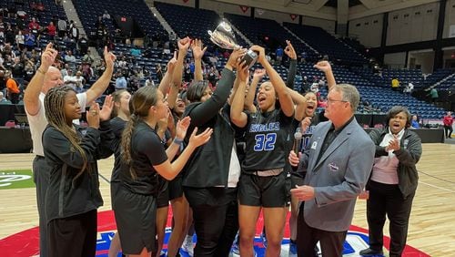 Mount Paran Christian head coach Stephanie Dunn, senior Ciara Alexander (32) and teammates celebrate with the trophy after their 59-52 victory over Josey in the Class 2A girls basketball championship game at the Macon Coliseum on March 7, 2024.