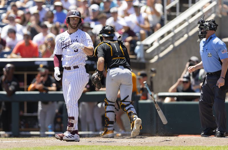 Texas A&M's Gavin Grahovac, left, tosses his bat after he struck out swinging against Tennessee to close out the third inning of Game 2 of the NCAA College World Series baseball finals in Omaha, Neb., Sunday, June 23, 2024. (AP Photo/Rebecca S. Gratz)