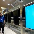 An employee walks past rebooting arrivals and departures screens at Phoenix Sky Harbor International Airport Friday, July 19, 2024, in Phoenix. An overnight outage was blamed on a software update that cybersecurity firm CrowdStrike sent to Microsoft computers of its corporate customers including many airlines. (AP Photo/Ross D. Franklin)