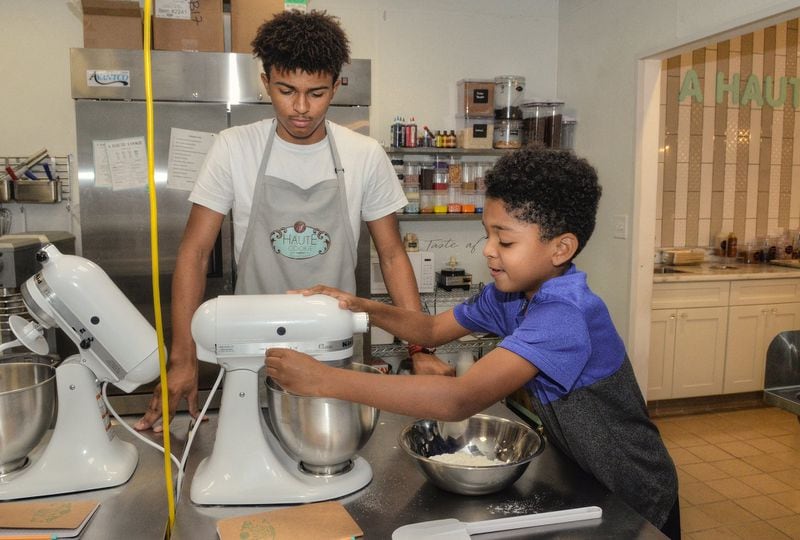 Cory Curtis, 17, helps Gionne Robinson, 10, with his version of Edible Sugar Cookie Dough. Mix-ins let kids make the recipe their own. CONTRIBUTED BY CHRIS HUNT PHOTOGRAPHY