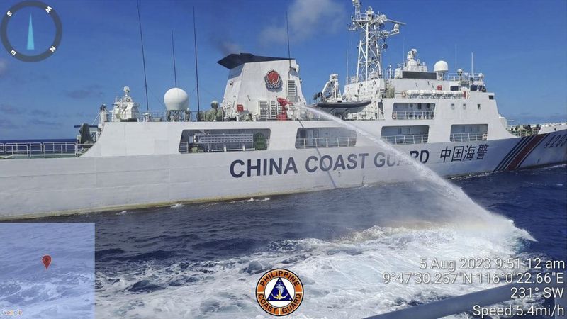 FILE - In this handout photo provided by the Philippine Coast Guard, a Chinese coast guard ship uses water canons on a Philippine Coast Guard ship near the Philippine-occupied Second Thomas Shoal, South China Sea as they blocked it's path during a re-supply mission on Aug. 5, 2023. The Philippine military chief demanded Wednesday that China returns several rifles and equipment seized by the Chinese coast guard in a disputed shoal and pay for damage it caused to two navy rubber boats in an assault he likened to an act of piracy in the South China Sea.. (Philippine Coast Guard via AP)