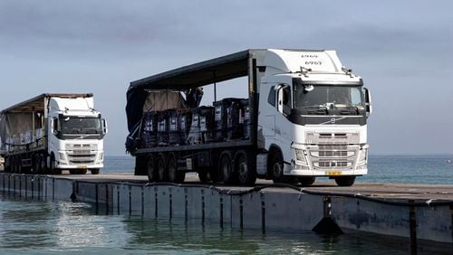 FILE - This image provided by the U.S. Army shows trucks loaded with humanitarian aid from the United Arab Emirates and the United States Agency for International Development cross the Trident Pier before arriving on the beach on the Gaza Strip, May 17, 2024. The U.S.-built pier to bring food to Gaza is facing one of its most serious challenges yet. The United Nations is deciding if it can keep safely delivering supplies from the U.S. sea route to starving Palestinians (Staff Sgt. Malcolm Cohens-Ashley/U.S. Army via AP, File)