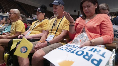 People pray before the start of the Moms for Liberty National Summit in Washington, Saturday, Aug. 31, 2024. (AP Photo/Jose Luis Magana)