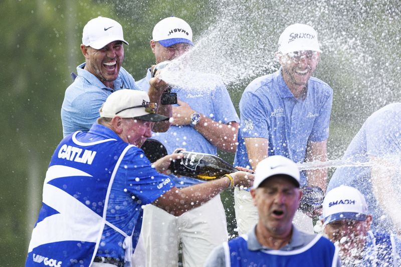 Team Champions Smash GC's captain Brooks Koepka, alternate John Catlin, Jason Kokrak and Talor Gooch celebrate onstage during the trophy ceremony with their caddies after the LIV Golf Greenbrier at The Old White at The Greenbrier, Sunday, Aug. 18, 2024, in White Sulphur Springs, W.Va. (Jon Ferrey/LIV Golf via AP)