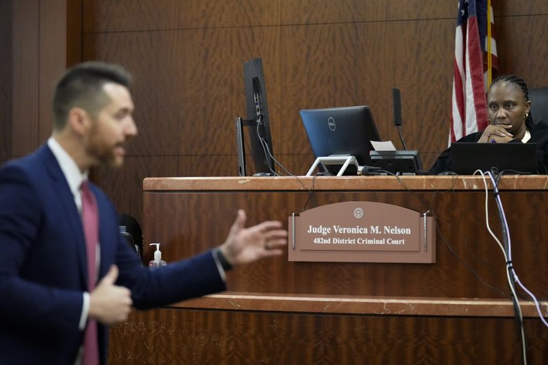 Judge Veronica M. Nelson listens to prosecutors Keaton Forcht delivering opening statement for the trial of retired Houston Police Department officer Gerald Goines at the 482nd District Court Monday, Sept. 9, 2024, at the Harris County Criminal Courthouse in Houston. Goines was on trial for two felony murder charges in the January 2019 deaths of Dennis Tuttle and Rhogena Nicholas. (Yi-Chin Lee/Houston Chronicle via AP)