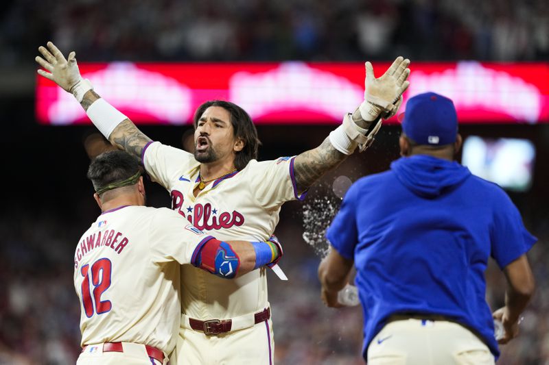 Philadelphia Phillies' Nick Castellanos celebrates with Kyle Schwarber and teammates his one-run single against New York Mets pitcher Tylor Megill during the ninth inning to win Game 2 of a baseball NL Division Series, Sunday, Oct. 6, 2024, in Philadelphia. (AP Photo/Matt Slocum)