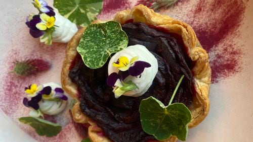 The beet root tart at Auburn Angel brings a stunning rose petal arrangement of cooked, sliced beets tucked inside a pastry shell with garnishes of goat cheese mousse, nasturtium leaves and flowers, crimson clover and beet root dust. (Ligaya Figueras/lfigueras@ajc.com)