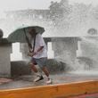 A man runs away from waves when he was walking along the shore in Kaohsiung, Southern Taiwan, Wednesday, Oct. 2, 2024, as Typhoon Krathon is expected to hit the area. (AP Photo/Chiang Ying-ying)