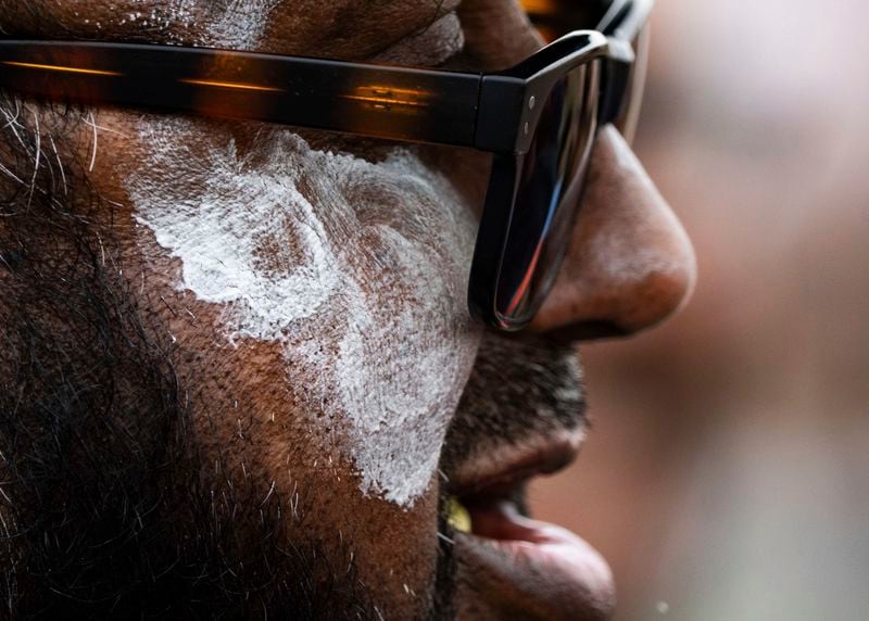 Sheaka Morshed wears sunblock on his face as temperatures climb into the high 90s Fahrenheit while watching the Team USA cricket match against Bangladesh, part of a three-game T20I series at the Prairie View Cricket Complex, Saturday, May 25, 2024, in Houston. (Jason Fochtman/Houston Chronicle via AP)