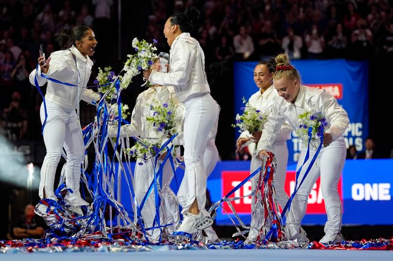 Jordan Chiles, left, and Suni Lee, center, jump in celebration after the team was named for 2024 Olympics at the United States Gymnastics Olympic Trials on Sunday, June 30, 2024, in Minneapolis. (AP Photo/Abbie Parr)