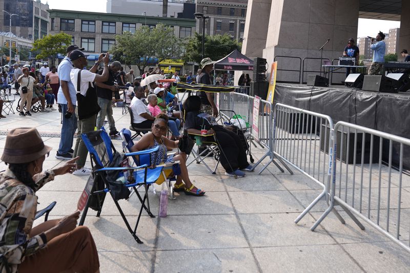 People attend a performance by JSWISS in the Harlem neighborhood of New York, Thursday, Aug. 15, 2024. (AP Photo/Pamela Smith)