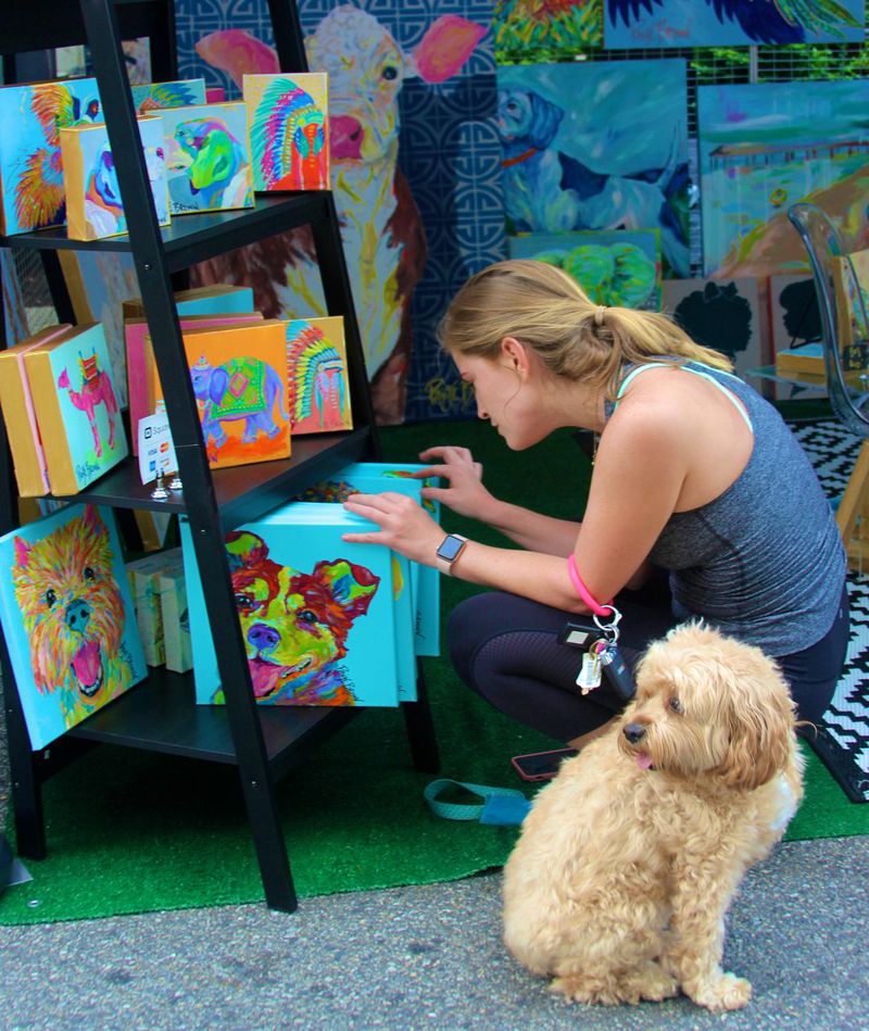 A festivalgoer with her pup shops for artwork at the Buckhead Arts Festival.