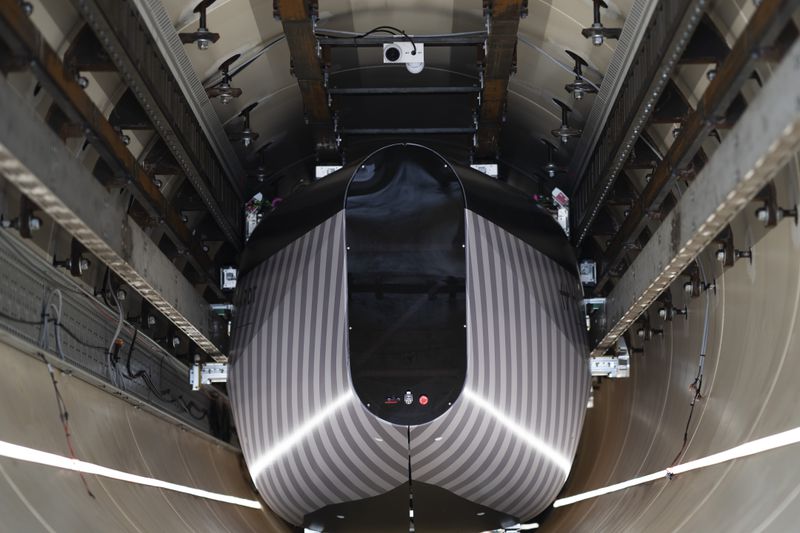 A test vehicle levitated by magnetic fields zips through a depressurized tube in a testing ground for a high-speed transit system during a press tour of an European test center for hyperloop transportation technology in Veendam, northern Netherlands, Friday, Sept. 6, 2024. (AP Photo/Peter Dejong)