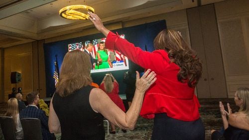 At a watch party for the GOP national convention, Georgia Republicans get excited as President Donald Trump approaches the stage to give his acceptance speech. Georgia Republicans have stepped up their voter outreach. Georgia GOP Executive Director Stewart Bragg says party staffers and volunteers in the state have made roughly 6 million voter contacts and knocked on 600,000 doors so far.  (Jenni Girtman for The Atlanta Journal-Constitution)