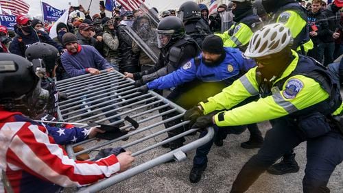 FILE - Supporters of President Donald Trump try to break through a police barrier, Jan. 6, 2021, during a riot at the Capitol in Washington. Former President Donald Trump said during a debate with President Joe Biden last week that the attack on the Capitol involved a "relatively small" group of people who were "in many cases ushered in by the police." (AP Photo/John Minchillo)