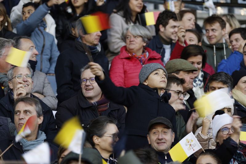 Faithful wave flags as Pope Francis arrives to lead the holy mass , at the King Baudouin stadium in Brussels, Belgium, Sunday, Sept. 29, 2024. (AP Photo/Omar Havana)