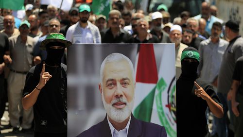 Hamas members hold a poster of Hamas political chief Ismail Haniyeh during a protest to condemn his killing, at al-Bass Palestinian refugee camp, in the southern port city of Tyre, Lebanon, Wednesday, July 31, 2024. Haniyeh, Hamas' political chief in exile who landed on Israel's hit list after the militant group staged its surprise Oct. 7 attacks, was killed in an airstrike in the Iranian capital early Wednesday. (AP Photo/Mohammed Zaatari)