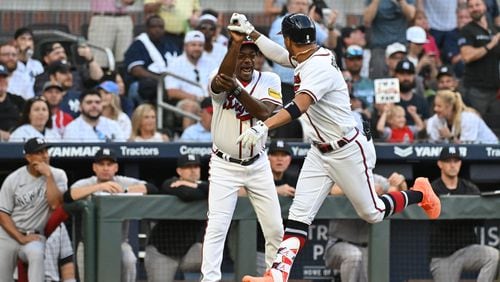 Braves' third base coach Ron Washington (left) celebrates with Eddie Rosario after his home run. (Hyosub Shin / Hyosub.Shin@ajc.com)