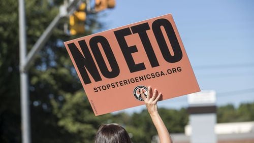 A Stop Sterigenics Georgia protestor holds a sign during a protest in near Smyrna. (Alyssa Pointer/alyssa.pointer@ajc.com)