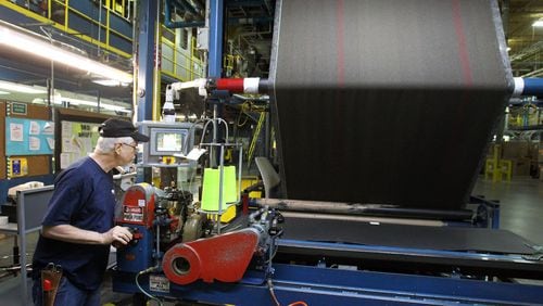 Worker at a "sew-on station" in a Shaw Industries plant. AJC File Photo