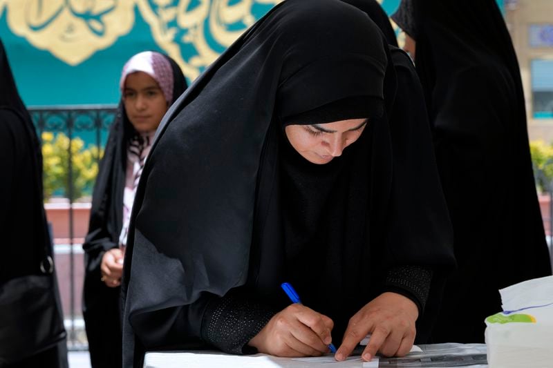 A woman fills out her ballot during the Iranian presidential election in a polling station at the shrine of Saint Saleh in northern Tehran, Iran, Friday, June 28, 2024. Iranians were voting Friday in a snap election to replace the late President Ebrahim Raisi, killed in a helicopter crash last month, as public apathy has become pervasive in the Islamic Republic after years of economic woes, mass protests and tensions in the Middle East. (AP Photo/Vahid Salemi)