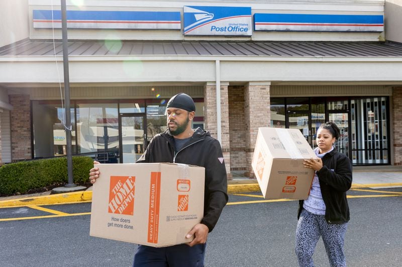 (L-R) Nate and Jade Bell leave the U.S. Post Office at Perimeter Village in Atlanta on Wednesday, December 27, 2023, after finding no employees inside. (Arvin Temkar / arvin.temkar@ajc.com)