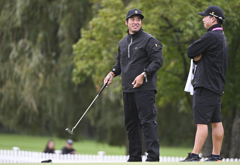 International team member Hideki Matsuyama, of Japan, left, jokes around on the putting green during practice at the Presidents Cup golf tournament, Monday, Sept. 23, 2024, in Montreal. (Graham Hughes/The Canadian Press via AP)