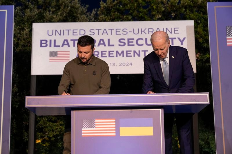 President Joe Biden, right, and Ukrainian President Volodymyr Zelenskyy sign a bilateral security agreement on the sidelines of the G7, Thursday, June 13, 2024, in Savelletri, Italy. (AP Photo/Alex Brandon)