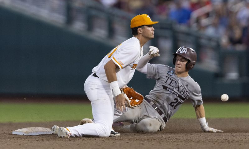 Texas A&M's Jackson Appel, right, steals second base ahead of a tag from Tennessee's Dean Curley in the sixth inning of Game 1 of the NCAA College World Series baseball finals in Omaha, Neb., Saturday, June 22, 2024. (AP Photo/Rebecca S. Gratz)
