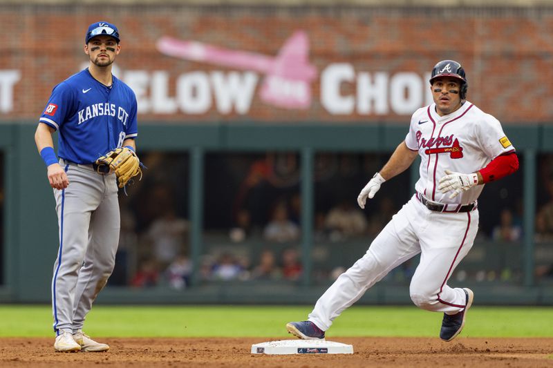 Atlanta Braves' Travis d'Arnaud, right, tags second base after a hit by Atlanta Braves catcher Sean Murphy while Kansas City Royals second baseman Michael Massey, left, waits for the throw to him in the fourth inning of a baseball game, Sunday, Sept. 29, 2024, in Atlanta. (AP Photo/Jason Allen)